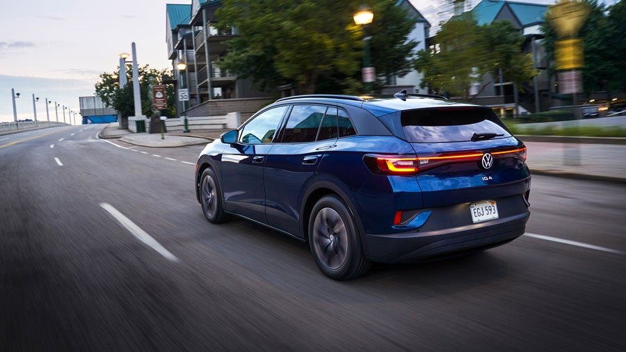 An ID.4 in Tourmaline Blue Metallic drives along a city street.